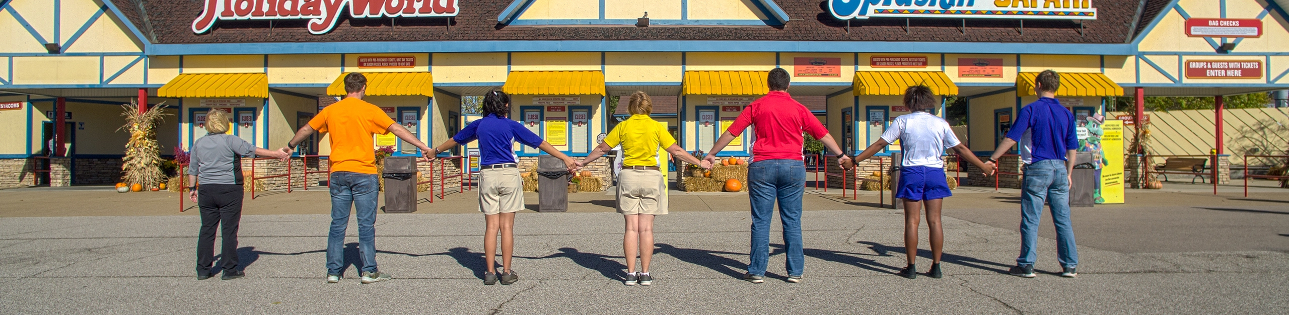 Team Members holding hands in front of the Front Gate at Holiday World & Splashin' Safari.
